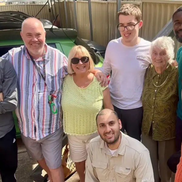 Group of smiling people standing outdoors, representing Maple Community Services’ supportive NDIS community.